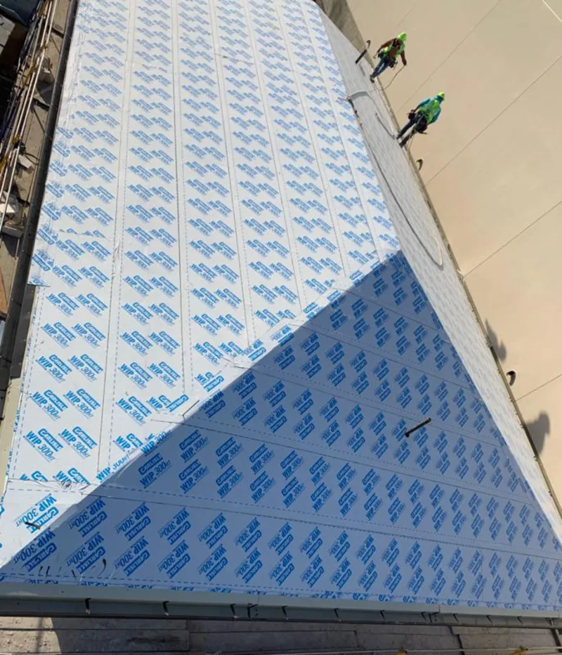 Professional roofers installing underlayment on a metal roof in East Rancho Dominguez